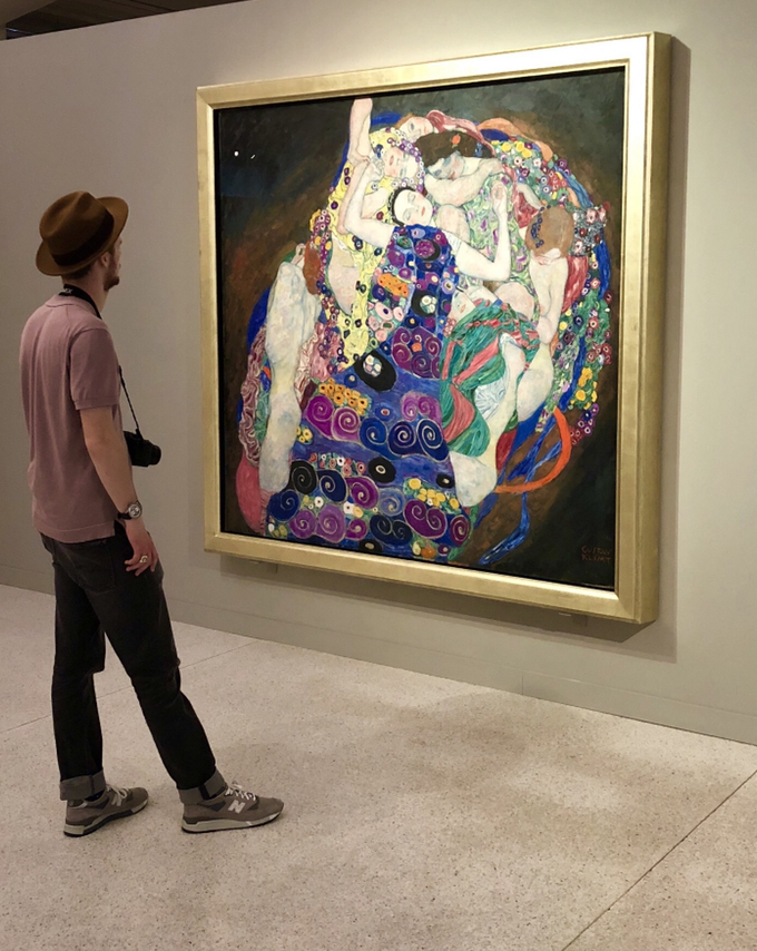 Young man viewing Gustav Klimt's painting "The Maiden". 
