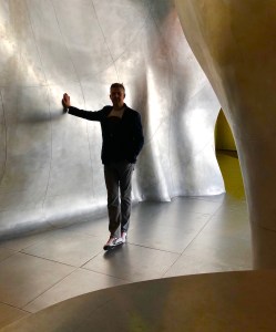 Man standing next to undulating wall at Centre George Pompidou. 